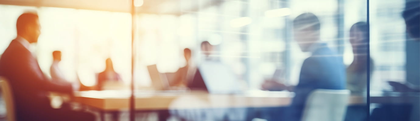 a blurred view of a team sitting in a meeting
