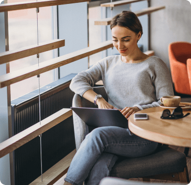 a woman working at a table with a laptop computer